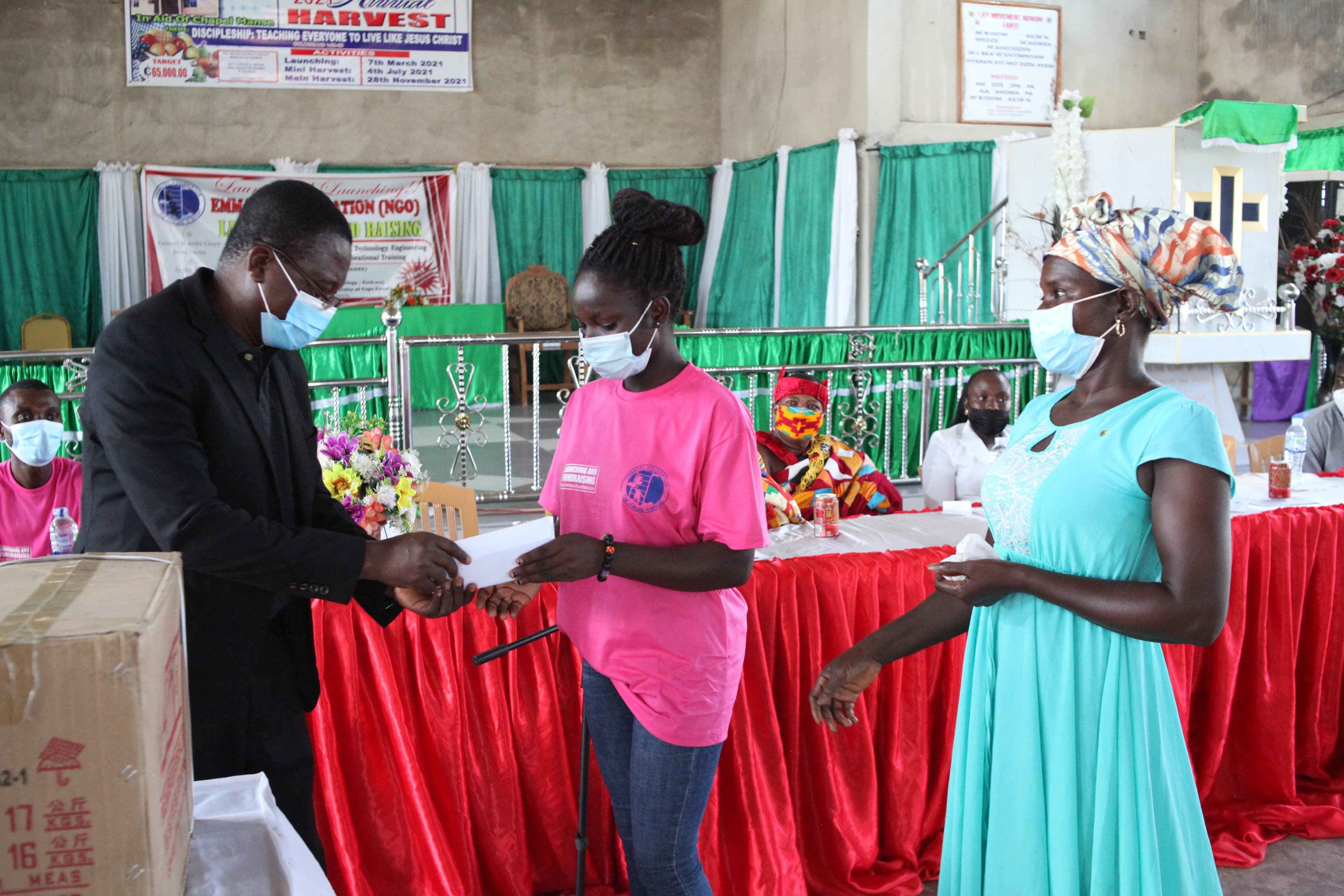 Hon. Amoah, DCE of Shama, presenting a cash prize to Gifty Arhin — Civil Engineering student at KNUST, Kumasi